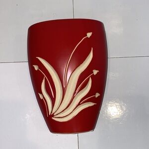 Brick red matte ceramic vase with white carved accents. 2” opening. 8” length.